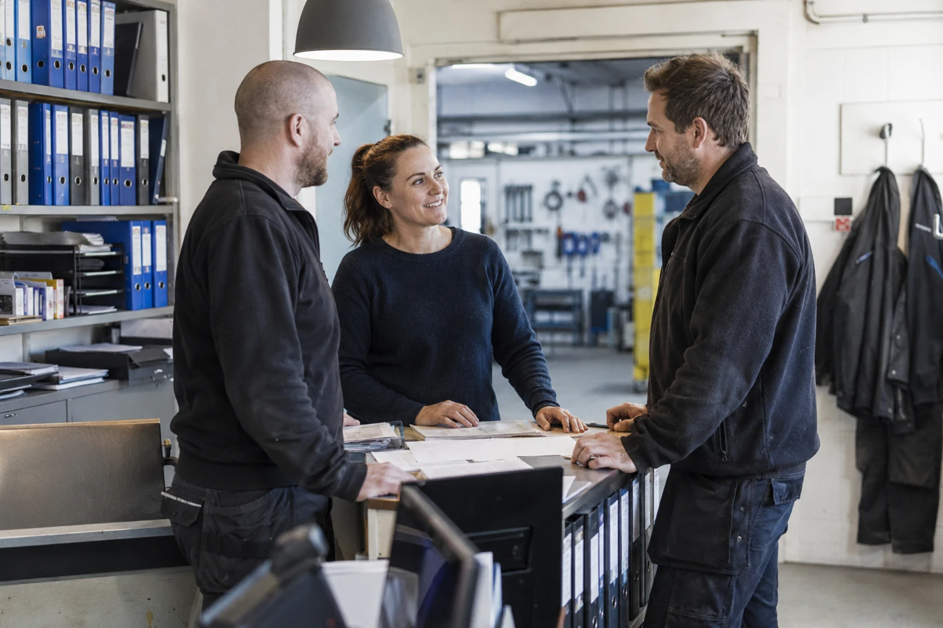 To mænd og en kvinde taler i en kontorindretning.